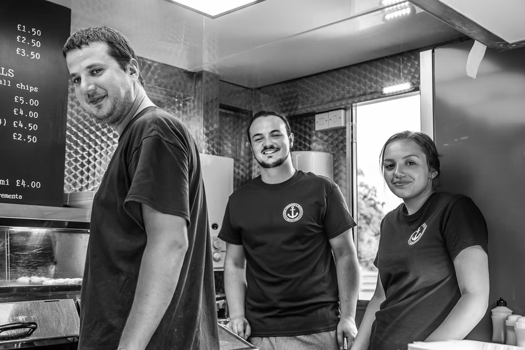 The Fishermen’s Chippy team working behind the counter preparing fish and chips