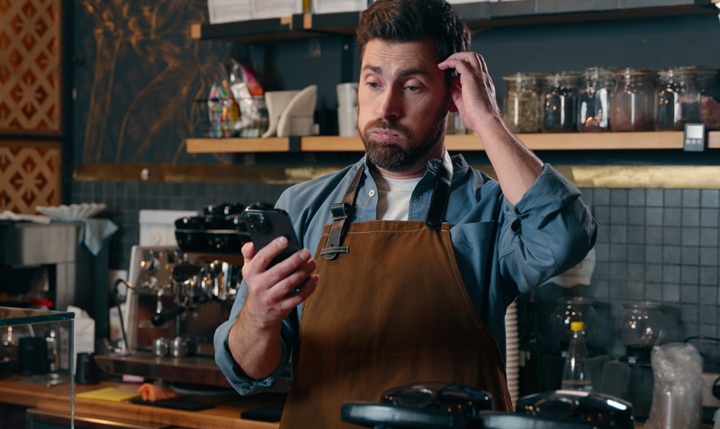 Barista struggling with disconnected retail and hospitality EPOS systems in a café environment