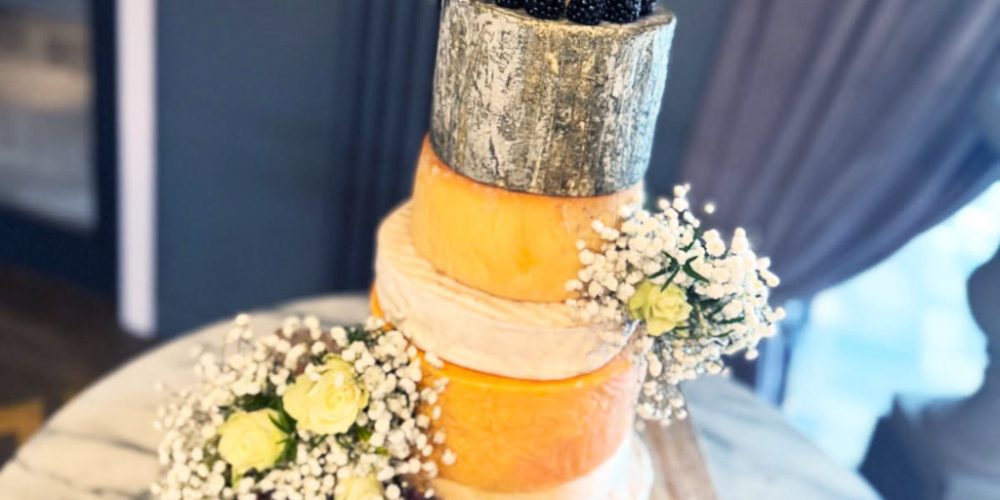 Wedding cake made from stacked artisan cheeses with flowers and fruit at Indie Füde in Belfast.