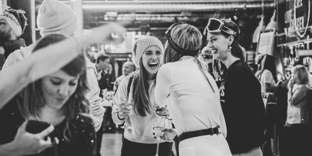 Guests laughing and socialising at a ski-themed event inside Café 360 on the Isle of Man