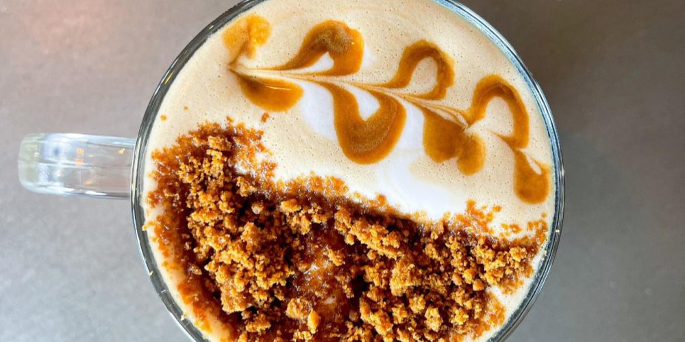 Caramel latte with latte art and crumb topping served at Café 360 on the Isle of Man