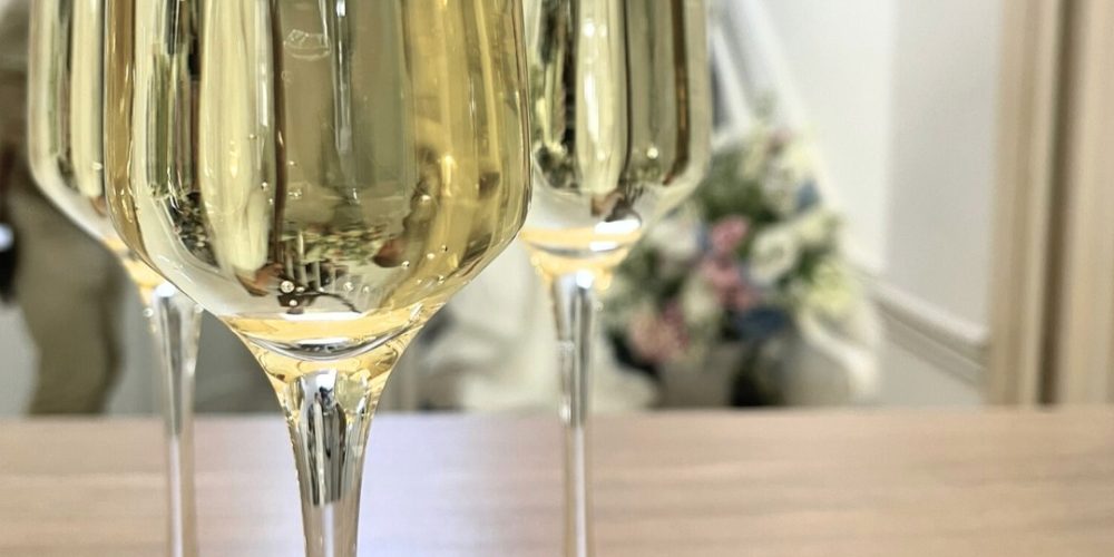 Champagne flutes filled with sparkling wine on a wooden table, ready for a celebration at Woodbourne House.