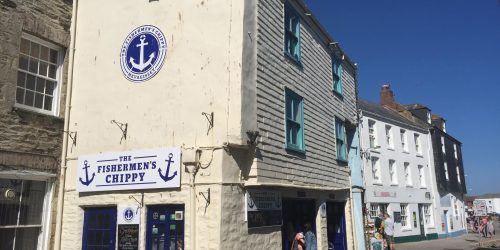 The Fishermen’s Chippy shopfront in Mevagissey, Cornwall on a sunny day