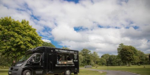 The Fishermen’s Chippy mobile fish and chips van set up at an outdoor event in a park