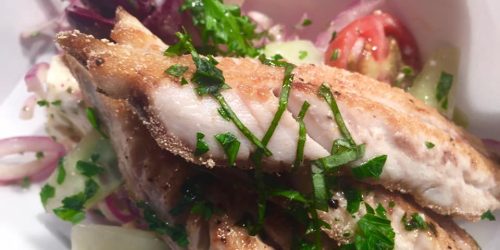 Pan-fried fish served with fresh salad at The Fishermen’s Chippy in Mevagissey