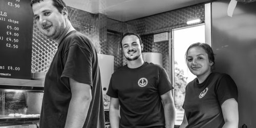 The Fishermen’s Chippy team working behind the counter preparing fish and chips
