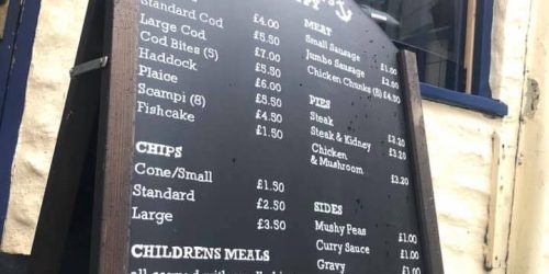 Traditional fish and chips menu board outside The Fishermen’s Chippy