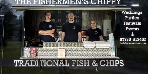 The Fishermen’s Chippy team serving traditional fish and chips from their mobile food truck