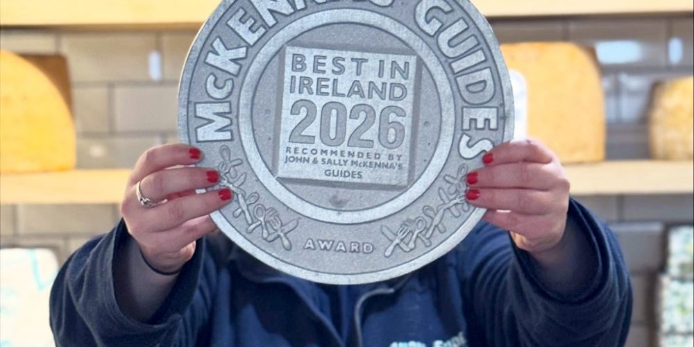Indie Füde holding McKenna’s Guides Best in Ireland 2026 award in the Belfast cheese shop.