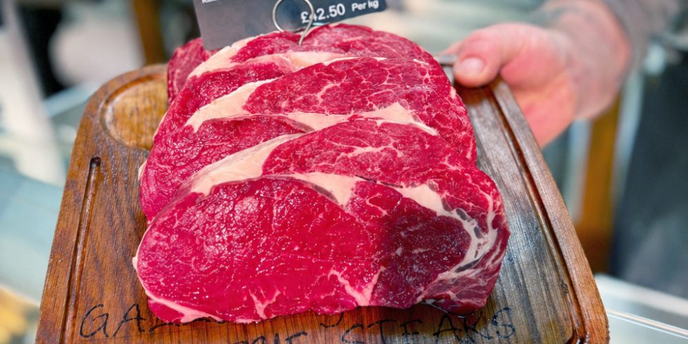 Rib-eye steaks displayed on wooden board at Kilnford Farm Shop butcher counter