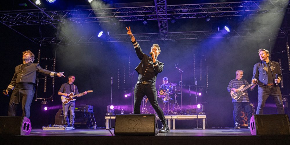 Live band performing on stage with professional lighting at an evening event at Woodbourne House on the Isle of Man.