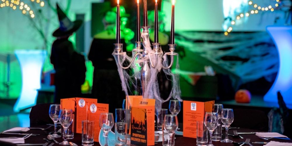 Styled event table with candle centrepiece and ambient lighting at Woodbourne House, an Isle of Man wedding and events venue.