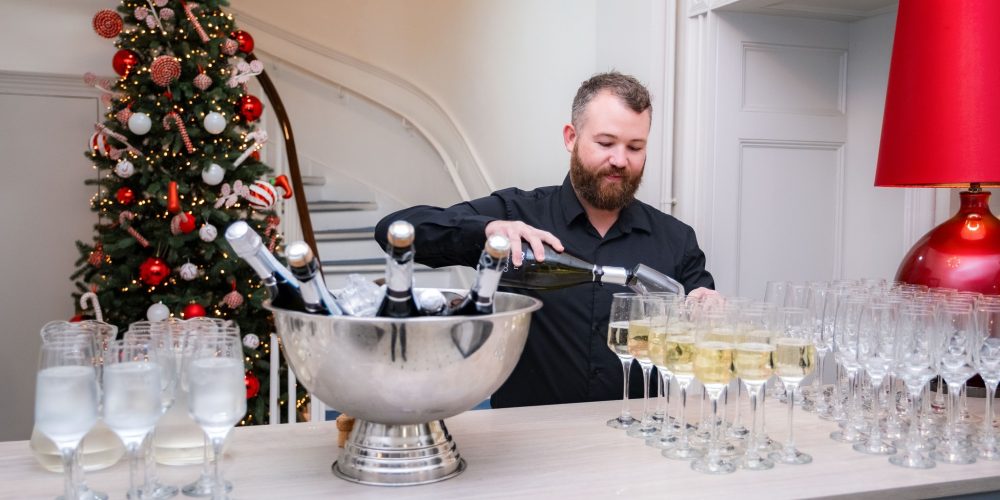 Staff serving champagne drinks for a wedding reception at Woodbourne House on the Isle of Man.