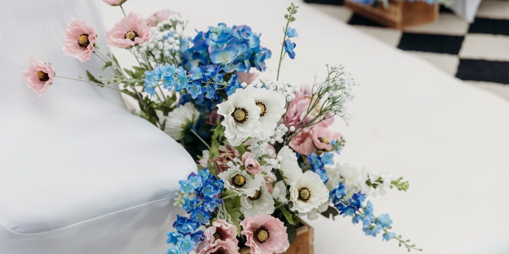Wedding floral arrangement with pastel flowers decorating ceremony seating at Woodbourne House on the Isle of Man.