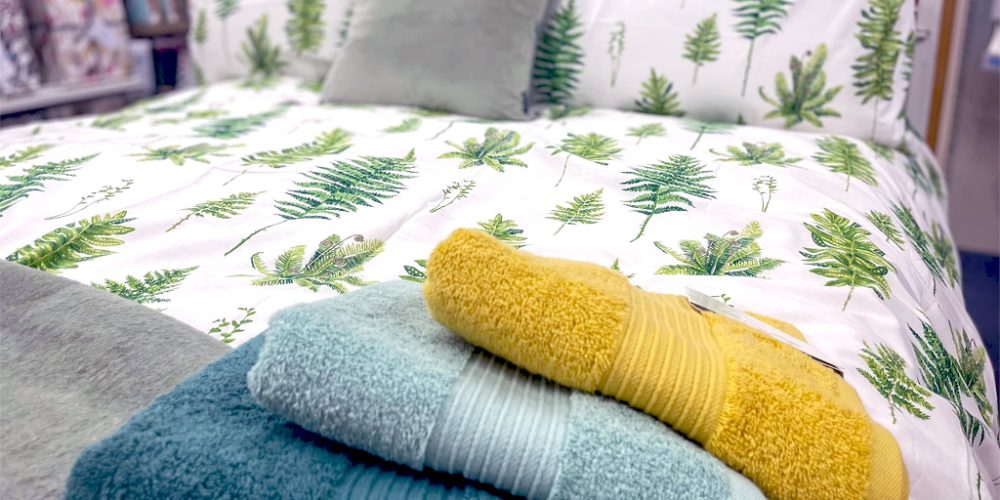 bed linen with leaf pattern and folded towels display